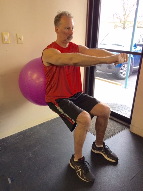 wall sits with ball for office exercise